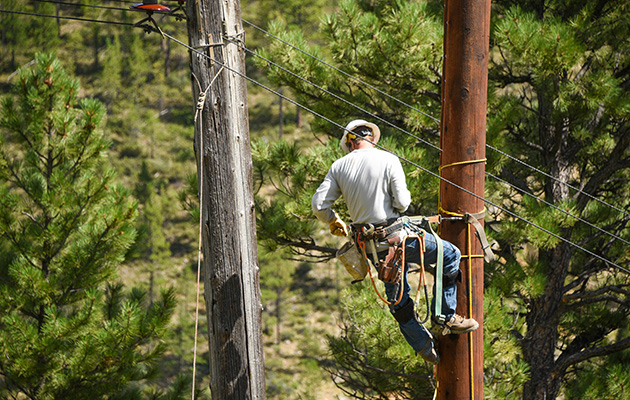 Photo of crew member climbing pole